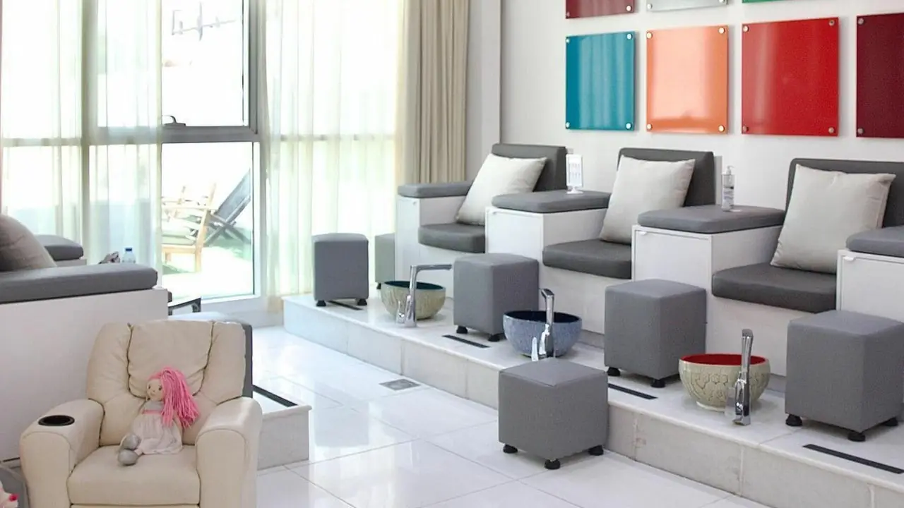 Pedicure chairs in front of the colour tile wall